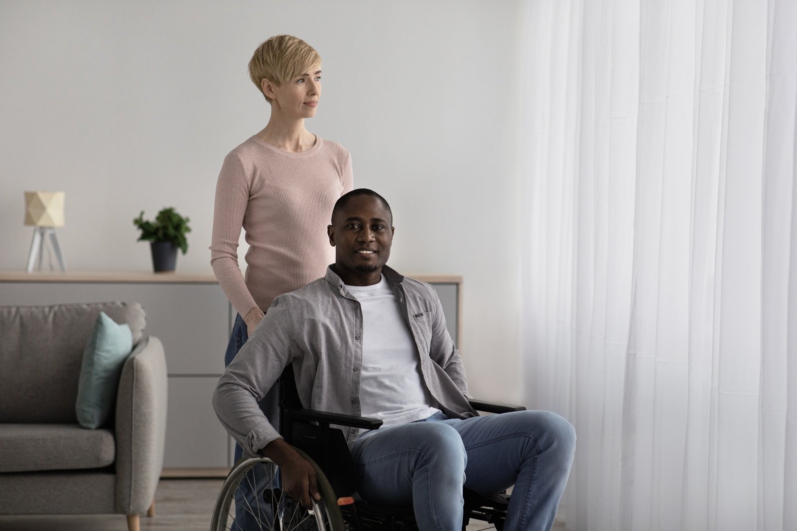 Home nurse caring for disabled patient. Multiracial family