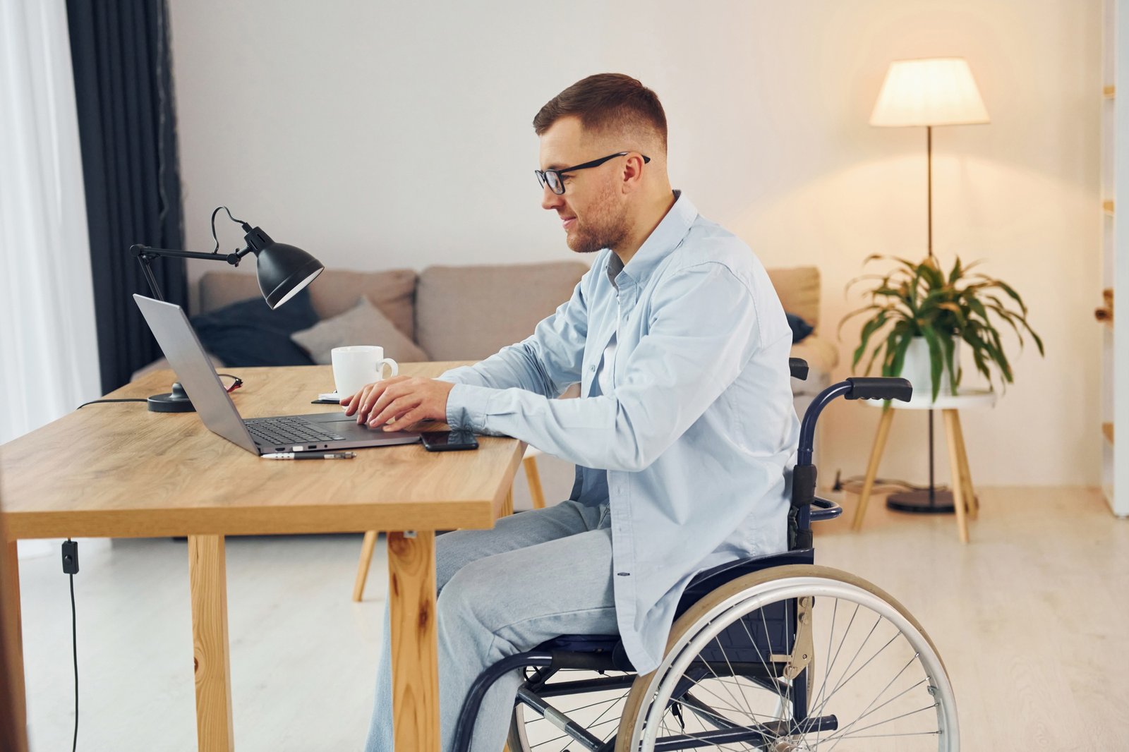 Smart freelance worker. Disabled man in wheelchair is at home